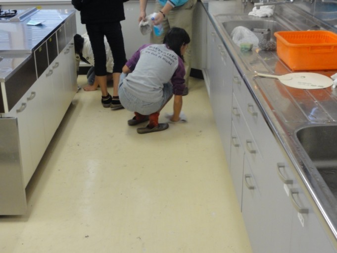 調理室の床の掃除中。雑巾がけをしています